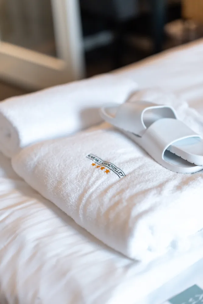 Närbild badrock och tofflor på sängkant