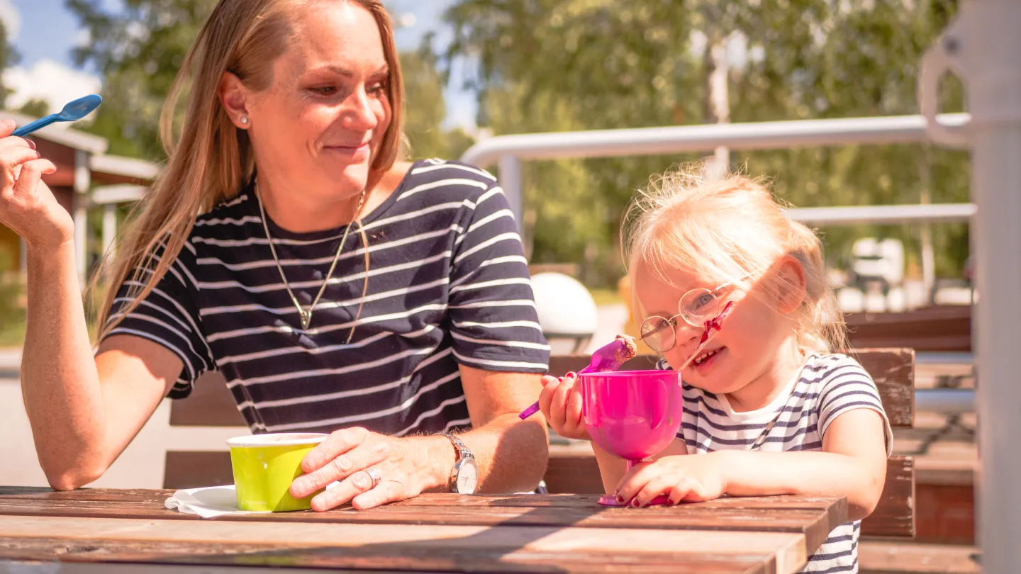 Familj med glass, sittandes vid bord utanför Cajsas Café